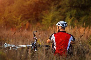 Image showing Young cute lady posing on a bike near the wall