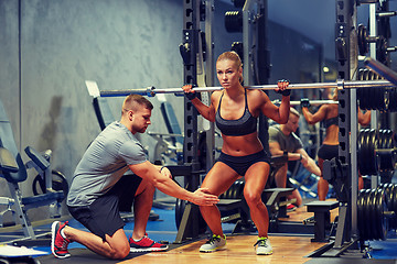 Image showing man and woman with barbell flexing muscles in gym