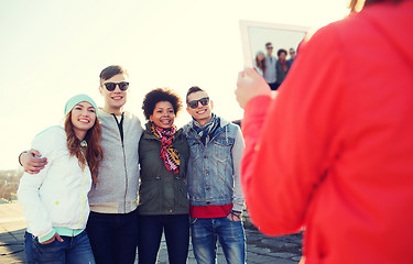 Image showing happy teenage friends with tablet pc photographing