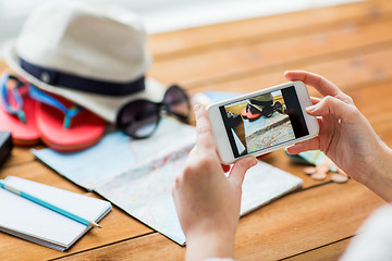 Image showing close up of woman with smartphone and travel stuff