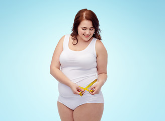 Image showing happy young plus size woman with measuring tape