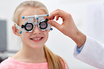 Image showing optician with trial frame and girl at clinic