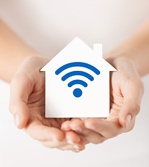 Image showing hands holding house with radio wave signal icon