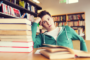 Image showing bored student or young man with books in library