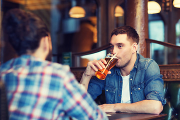 Image showing happy male friends drinking beer at bar or pub