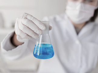 Image showing close up of woman with flask making test in lab