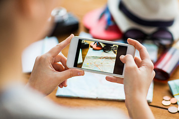 Image showing close up of woman with smartphone and travel stuff