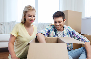 Image showing smiling couple with big boxes moving to new home