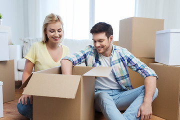 Image showing smiling couple with big boxes moving to new home