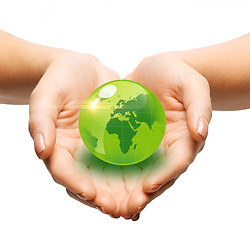 Image showing close up of woman holding green globe in her hands