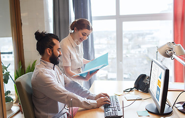 Image showing happy creative team with computer in office