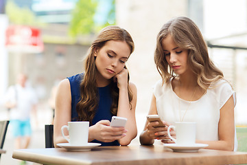 Image showing women with smartphones and coffee at outdoor cafe