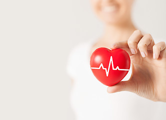 Image showing close up of hand with cardiogram on red heart