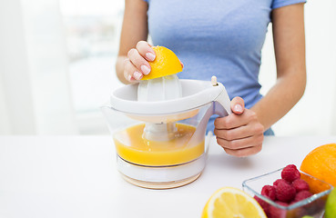 Image showing close up of woman squeezing fruit juice at home