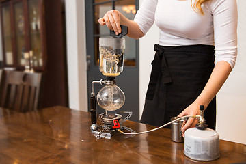 Image showing close up of woman with siphon coffee maker and pot