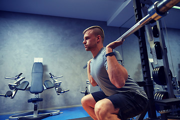 Image showing young man flexing muscles with barbell in gym