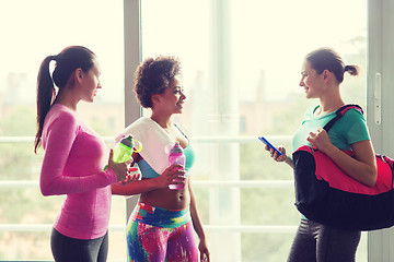 Image showing happy women with bottles of water in gym