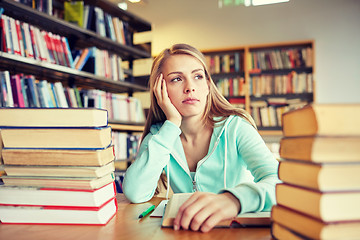 Image showing bored student or young woman with books in library