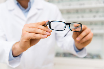 Image showing close up of optician with glasses at optics store