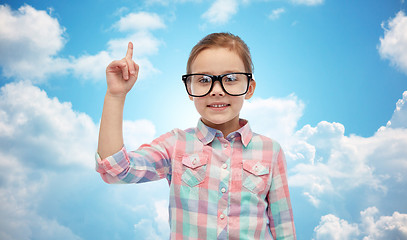 Image showing happy little girl in eyeglasses pointing finger up