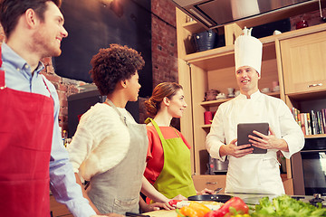 Image showing happy friends with tablet pc in kitchen