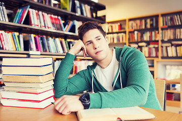 Image showing bored student or young man with books in library