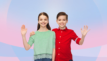 Image showing happy boy and girl waving hand