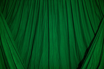 Image showing Draped black background cloth lit with green gel