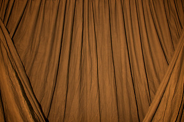 Image showing Draped black background cloth lit with orange gel