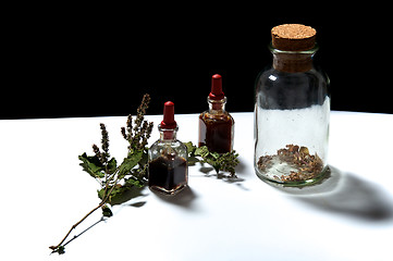 Image showing three glass bottles with herbal extracts and dried herbs