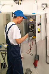 Image showing Young electrician performs task of competition