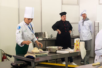 Image showing Girl-cook prepares food in competition