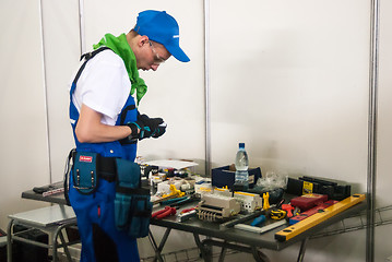 Image showing Young electrician performs task of competition