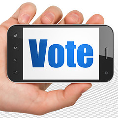 Image showing Politics concept: Hand Holding Smartphone with Vote on display