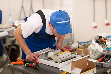 Image showing Young electrician performs task of competition