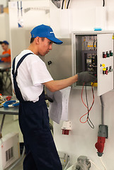 Image showing Young electrician performs task of competition