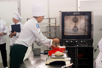 Image showing Girl-cook prepares food in competition