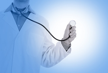 Image showing Close up of a Doctor\'s hand, holding a stethoscope, medical blue