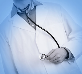 Image showing Close up of a Doctor\'s hand, holding a stethoscope, medical blue