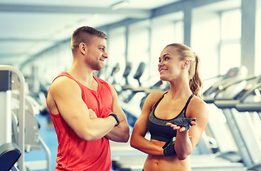 Image showing smiling man and woman talking in gym