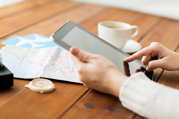 Image showing close up of traveler hands with tablet pc and map