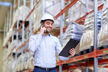 Image showing man with clipboard and smartphone at warehouse