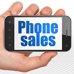 Image showing Advertising concept: Hand Holding Smartphone with Phone Sales on display