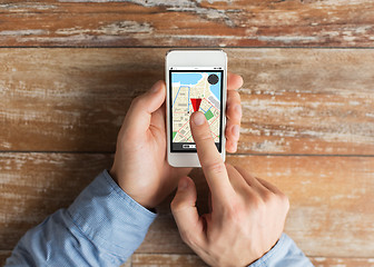 Image showing close up of male hands with smartphone on table