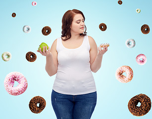 Image showing young plus size woman choosing apple or cookie
