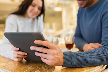 Image showing happy couple with tablet pc drinking tea at cafe