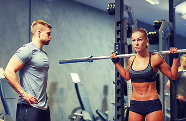 Image showing man and woman with barbell flexing muscles in gym