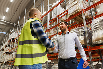 Image showing worker and businessmen with clipboard at warehouse