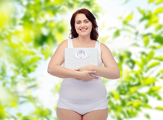 Image showing happy young plus size woman holding scales