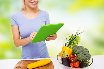 Image showing close up of woman with tablet pc cooking at home